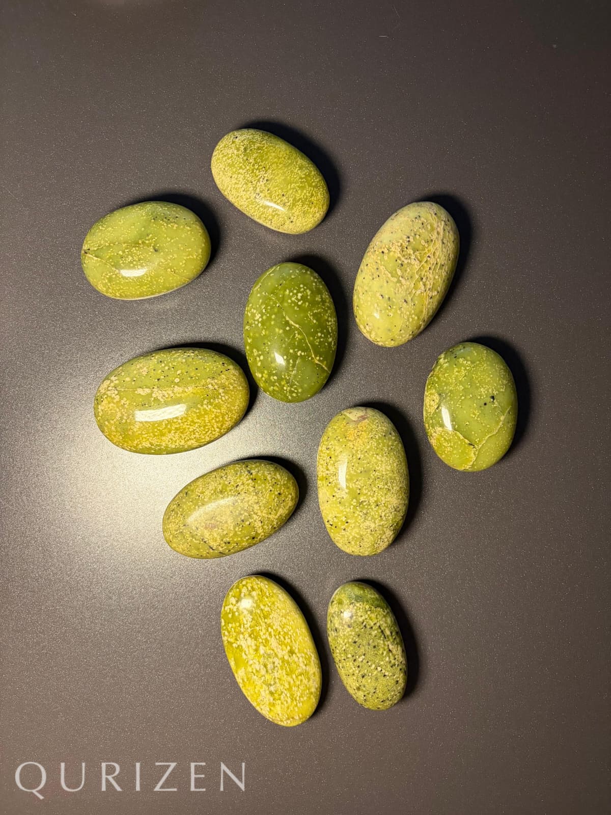 Green stones on a dark surface with 'Qurizen' branding.