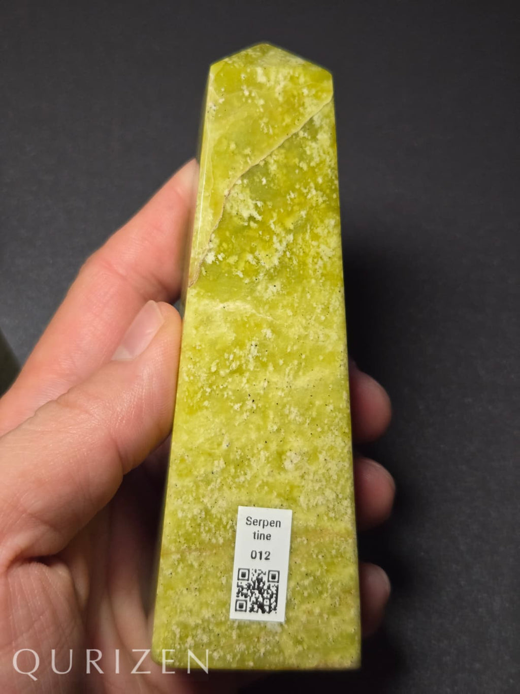 Green stone held in a hand with 'Qurizen' branding and a QR code label on a dark background