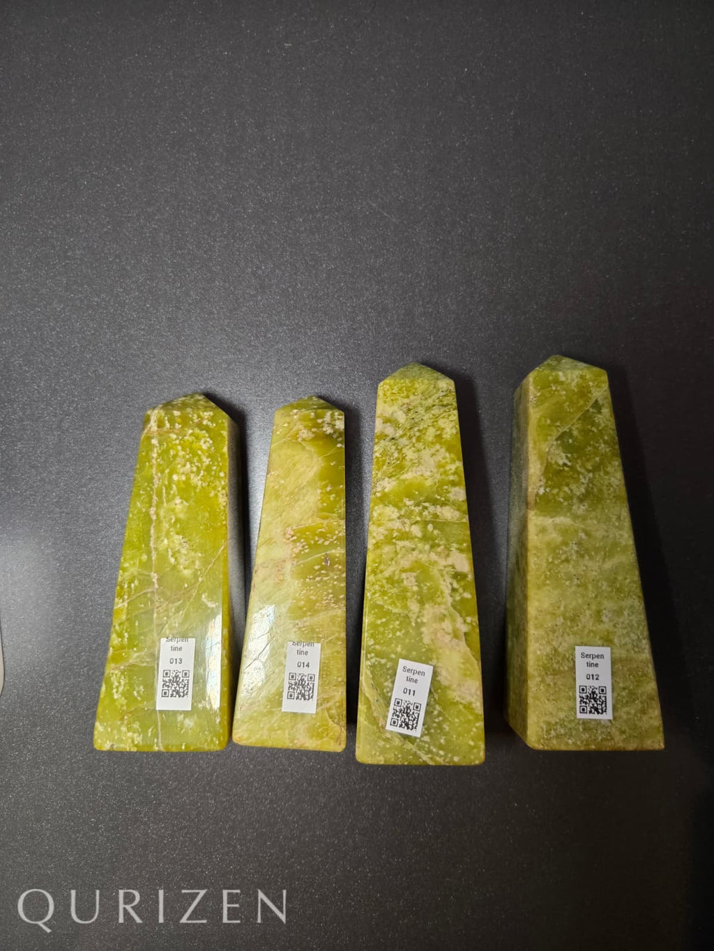 Four green stone wedges with QR codes on a dark gray background, branded 'Qurizen'.